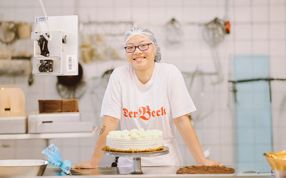 Konditorin in Ausbildung mit einer Torte