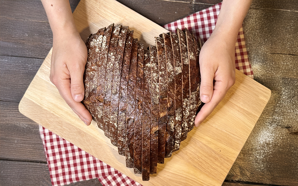 Hände halten ein Brot  in Herzform